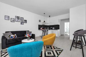 马卡尔斯卡Apartments Morpheus的客厅配有黑色沙发和黄色椅子
