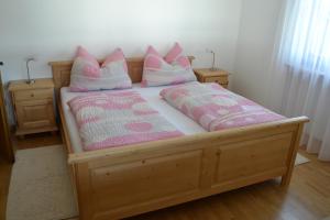布鲁尼科Apartment Lukas Huber的一张带粉色和白色枕头的木床