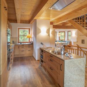 魏森湖Villa Ruah的一间铺有木地板和木制天花板的大厨房