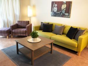 NorddalNorway Holiday Apartments - Norddalstunet的客厅配有黄色沙发和茶几