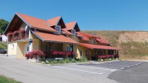 拉科维察巴弗力克公寓酒店的停车场里一座有红色屋顶和鲜花的建筑