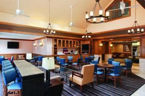 艾迪生Hyatt House Dallas Addison的一间设有蓝色椅子的餐厅和一间酒吧