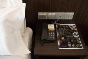 双溪大年赛日马来西亚斯昂盖皮塔尼酒店的一张桌子上的电话,床边