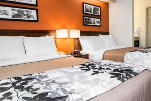 布里奇波特Quality Inn Bridgeport-Clarksburg的橙色墙壁的酒店客房内的两张床