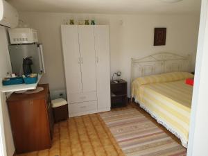 加利亚诺德尔卡波Santa Maria Di Leuca Villa Etta的一间卧室配有床和白色的大橱柜