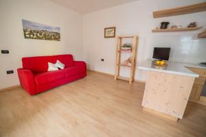 福尔加里亚Rothaus的一间带红色沙发的客厅和一间厨房