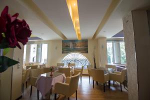雅典凯帆酒店的用餐室设有桌椅和窗户。
