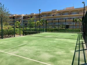 圣卡洛斯拉腊皮塔金沙滩公寓 的大楼前的网球场