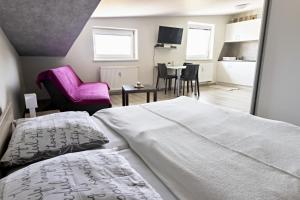 维尔奇斯拉夫科夫Apartmán Theo的一间卧室配有两张床和一张粉红色的椅子