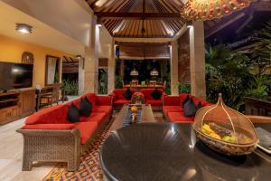 乌布必达达利私密别墅度假酒店的客厅配有红色的沙发和桌子