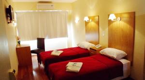 布宜诺斯艾利斯约拉门托里尔塔联排别墅酒店的两张位于酒店客房的床铺,配有红色床单