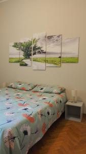 摩德纳Ferrari Suite Modena的卧室配有一张壁挂着四幅画作的床