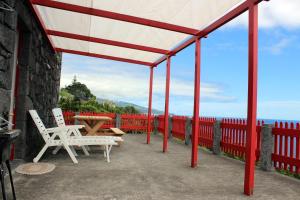 拉日什杜皮库阿瓜达别墅的庭院配有两把白色椅子和一张桌子