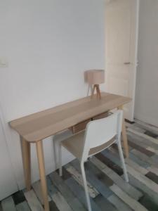 瑟堡CHE F2 Face SWEET HOME wifi的一张木桌,旁边配有一张白色椅子
