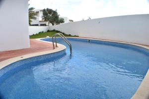吉亚Villa Amendoeira-POOL HEATED的一座房子前面的蓝色海水游泳池