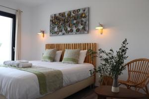 博尼法乔Hotel Fazio的一间卧室配有一张带白色床单和椅子的床