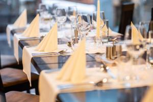 布拉迪斯拉发BNC酒店 - 餐厅 - 保龄球的一排带酒杯和餐巾的桌子
