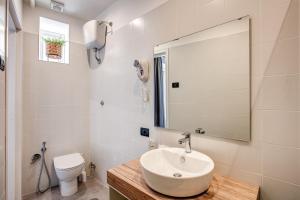 罗马国王酒店的一间带水槽、卫生间和镜子的浴室