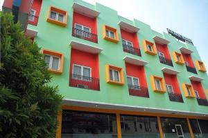 帕卢RedDoorz At Hotel Gajah Mada Palu的橙色和绿色的多彩建筑
