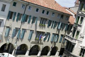 乌迪内意大利阿斯托瑞亚酒店的街道上一座带蓝色百叶窗的大建筑