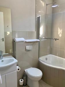 比勒陀利亚Hotel AT Hatfield Apartments的浴室配有卫生间、盥洗盆和浴缸。
