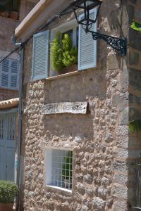 索列尔伊科塞雷住宿加早餐旅馆的一座石头建筑,有两个窗户,上面有标志