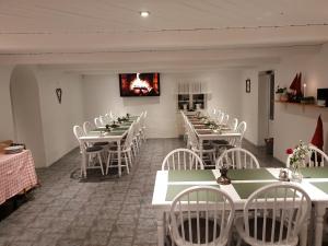 图默利拉兰德特住宿加早餐旅馆的一间带桌子、白色椅子和壁炉的用餐室