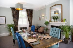 灵伍德Moortown Lodge B&B的一间带桌子和蓝色椅子的用餐室