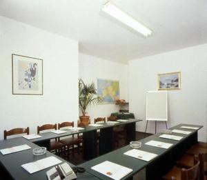 塞勒里古里维埃拉酒店的配有桌椅和白色墙壁的房间