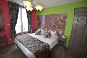 勒特雷波尔加来酒店的一间卧室设有一张大床和色彩缤纷的墙壁