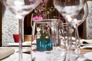 Mondéjar卡瑟纳托雷斯酒店的一张桌子,上面有酒杯和一瓶鲜花