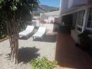 滨海普雷米亚agradable y familiar的房屋内带两个白色长椅的庭院