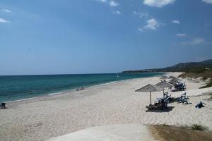 卡斯特罗西基亚Nepheli Hotel的海滩上设有椅子和遮阳伞,还有大海
