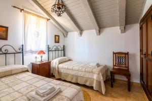 科尼尔-德拉弗龙特拉Villas Dehesa Roche Viejo的一间卧室设有两张床、一张桌子和一个窗口