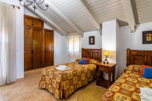 科尼尔-德拉弗龙特拉Villas Dehesa Roche Viejo的一间卧室设有两张床、一张桌子和一个窗口
