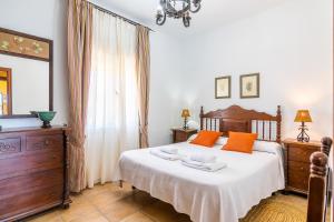 科尼尔-德拉弗龙特拉Villas Dehesa Roche Viejo的一间卧室配有一张带橙色枕头的大床