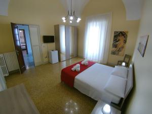 普雷西切Palazzo Rondine - Affittacamere con cucina的一间卧室配有一张带红色和白色床单的大床