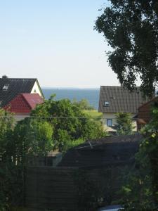 蒂索Uns Gartenhus mit Blick auf das Meer的一组房子和树木,背靠大海