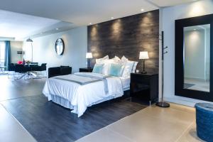 阿雷西费Rooms & Suites Loft 2E Deluxe Edition Arrecife的一间卧室配有一张大床和一张书桌