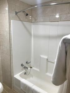 托纳万达蓝色瀑布汽车旅馆的浴室配有白色浴缸和淋浴。