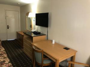 托纳万达蓝色瀑布汽车旅馆的酒店客房配有书桌和带电视的桌子。