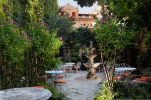 威尼斯弗洛拉酒店的一个带桌椅的花园和一个喷泉