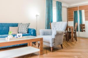 里桑海之星公寓的客厅配有蓝色的沙发和椅子
