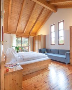 魏森湖Villa Ruah的一间卧室配有一张大床和一张蓝色的沙发