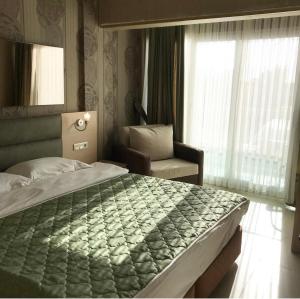 图尔古特雷斯Marin-A Hotel & Spa Turgutreis的卧室配有床、椅子和窗户。