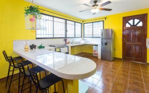 巴利亚多利德Casa Flamingo的厨房设有黄色的墙壁、桌子和冰箱