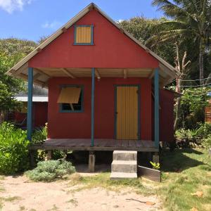 玉米岛Sunrise Paradise/Carlito´s Place的红色的房子,有黄色的门和门廊