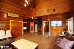 古坑湖光山舍的客厅设有木墙、沙发和电视