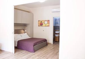 陶尔米纳Casa Lorenzo的一间卧室配有一张带紫色毯子的床
