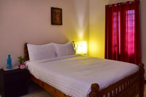 蓬蒂切里Villa Gomez的一间卧室配有一张带红色窗帘的大床
